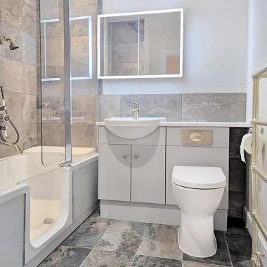 AFTER: Renovated bathroom with walk-in bath, accessible shower and new suite