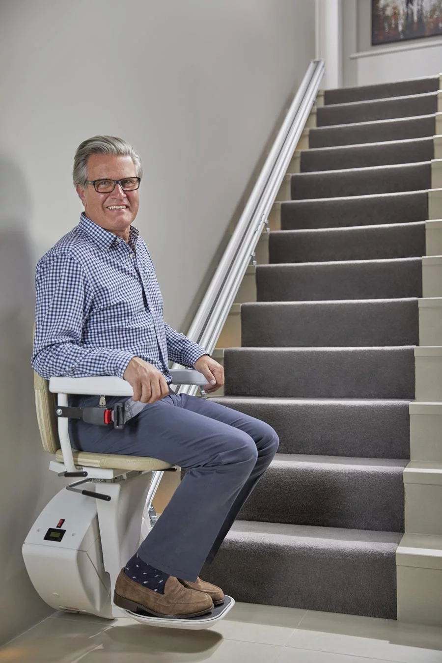 Older man sitting on a stair lift
